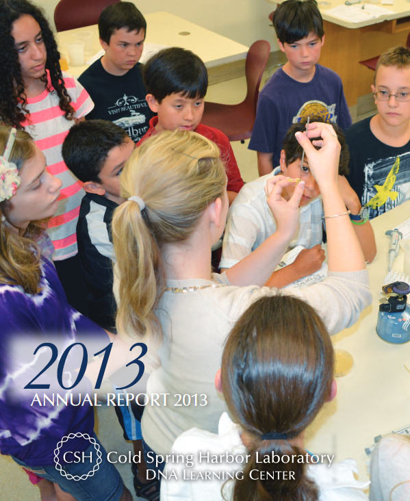 Annual report cover with a color photo of a DNALC educator demonstrating use of a loop to tease out DNA during an extraction with several middle school age students looking on