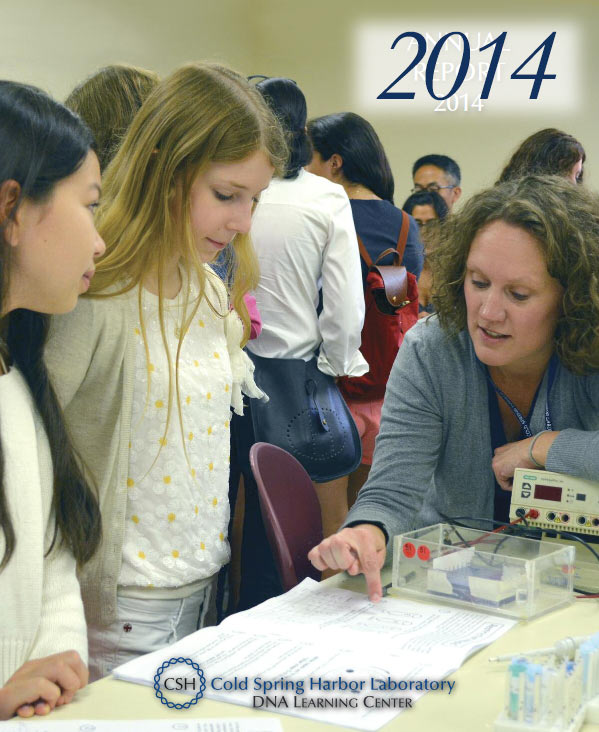Annual report cover with a color photo of a DNALC educator pointing out a step in a lab experiment on a paper with two middle school age girls looking on with other poeple in the background