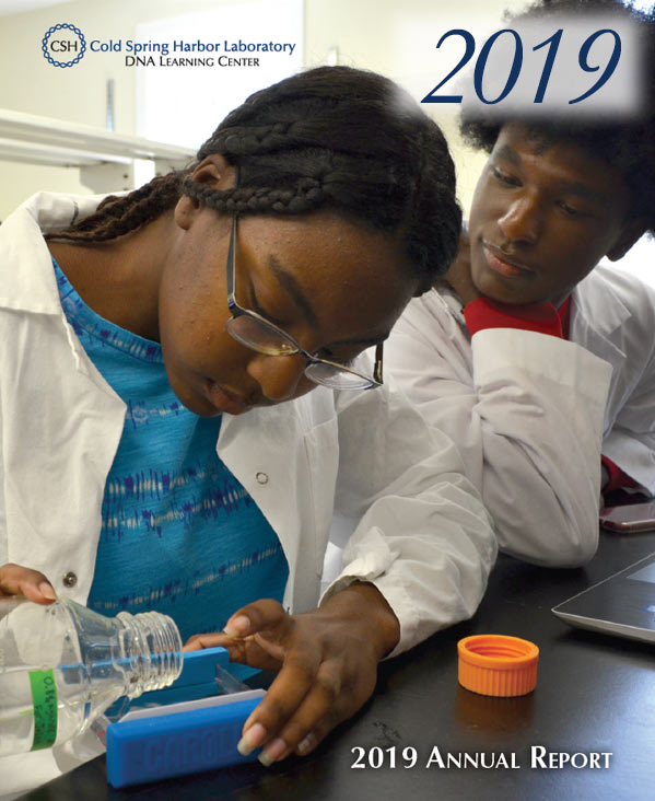 Annual report cover with two students in white lab coats pouring liquified agarose into a gel block set up
