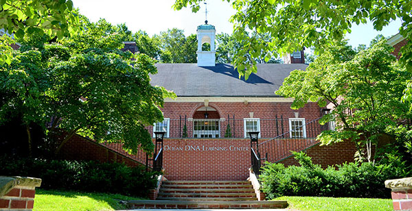 Dolan DNA Learning Center building on a sunny day framed by green trees and grass