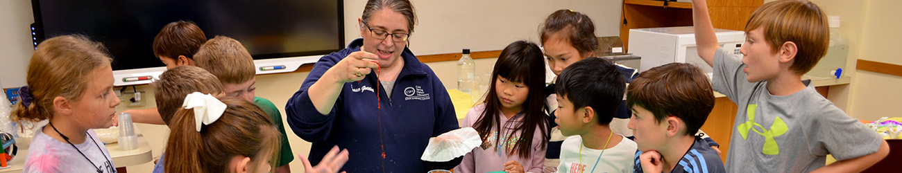Wide view of students and their instructor in a DNALC lab classroom doing a science experiment