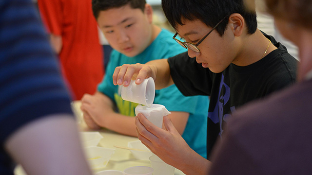 Students in a lab classroom doing a science experiemnt using plastic cups