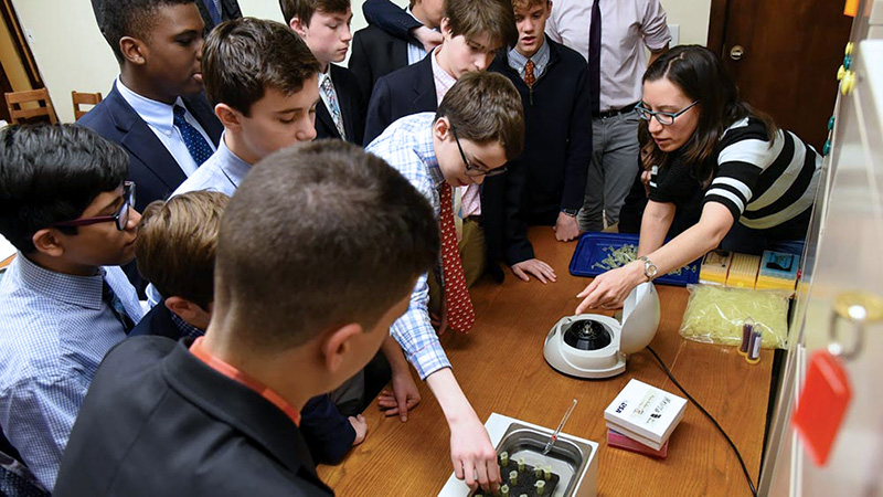 A group of students around a table using centrifuge and water bath