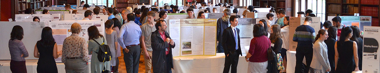 DNA Barcoding symposium with several people moving and conversing between tables with posters mounted on science fair poster boards